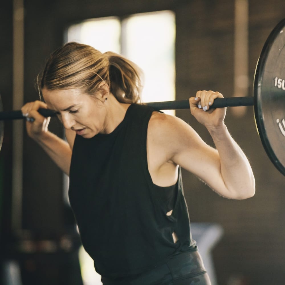 Woman lifting barbell at CrossFit 801
