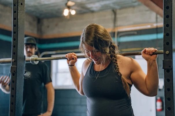 Happy woman lifting barbell at CrossFit 801