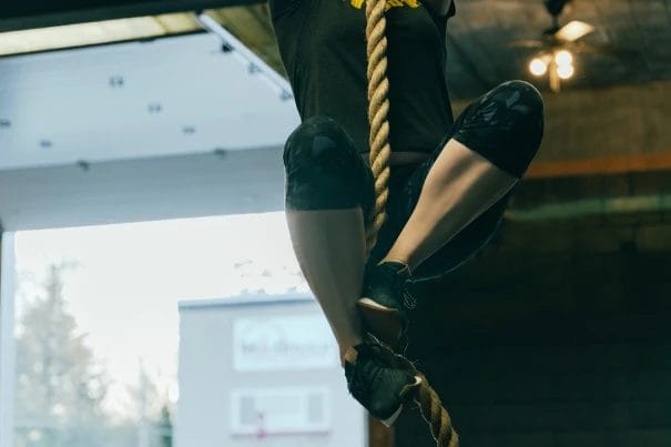 Woman climbing a rope at CrossFit 801